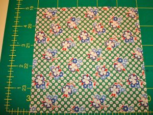Single charm square laid out on cutting mat - size is 5"x5"